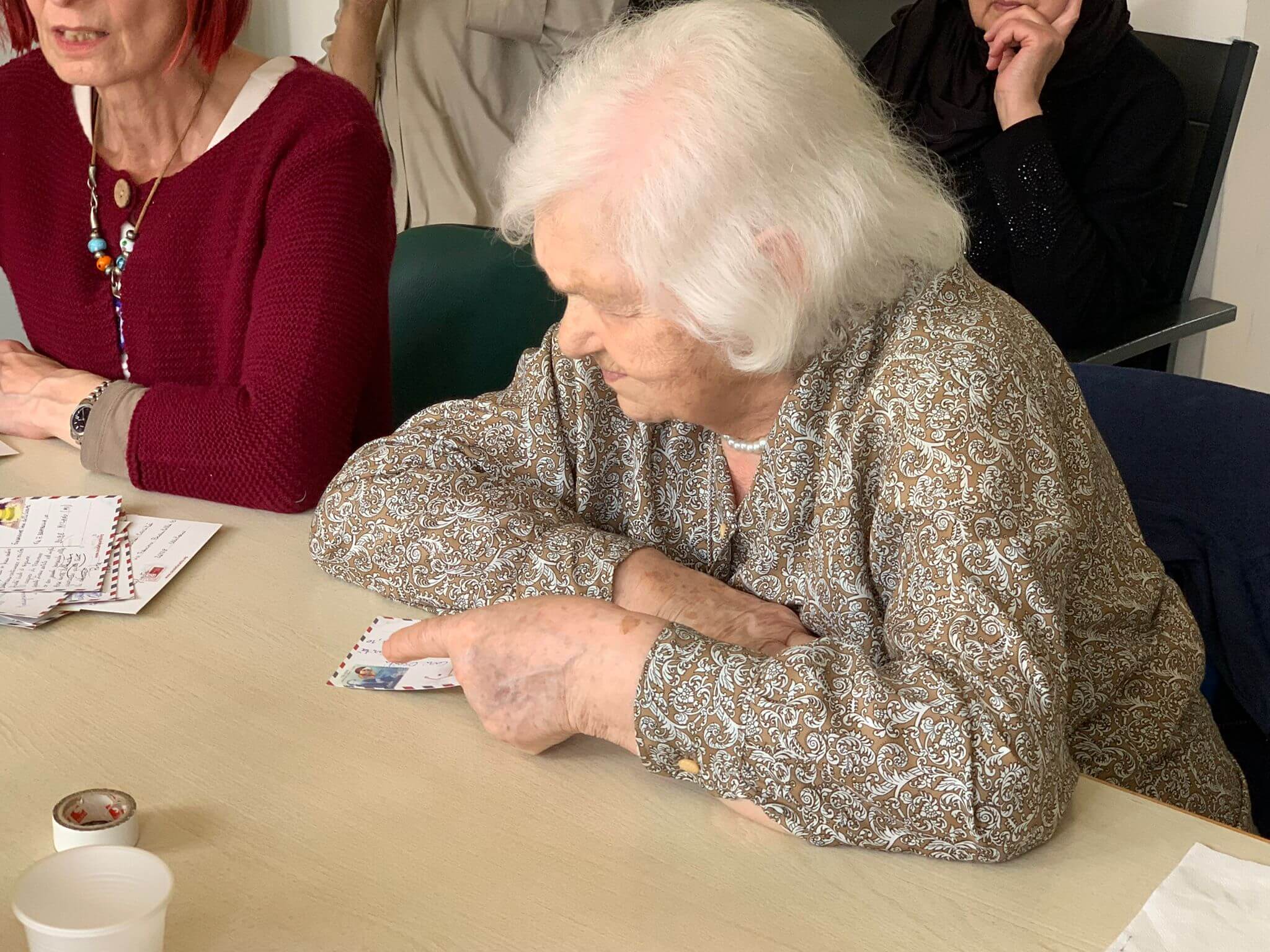 Anziani leggono cartoline donatori